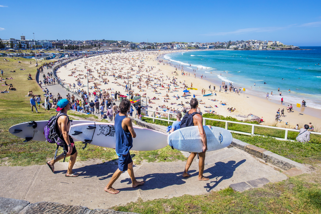 Sydney, Australia - November 19, 2015: Three surfers heading to the Bondi Beach Bondi beach with their surf boards on a sunny day.